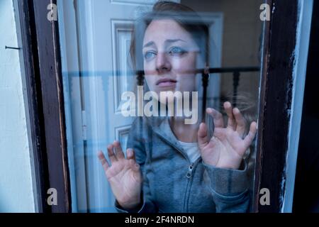 Jeune belle dépression malheureux femme caucasienne regardant inquiet et triste par la fenêtre à la maison. Se sentir sans valeur et dans la douleur. gros plan. Depressi Banque D'Images