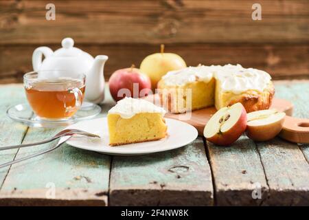 Délicieux gâteau à l'ancienne avec glaçage à la crème servi avec du thé et pommes crues sur table de shabby turquoise copyspace Banque D'Images