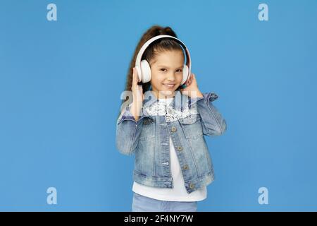 une petite fille en casque blanc danse Banque D'Images