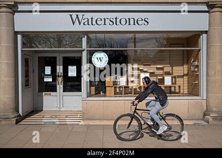 Yound, homme à vélo, près d'une succursale de Waterstoneson Princes Street, Édimbourg, Écosse, Royaume-Uni, pendant le second confinement de covid. Banque D'Images