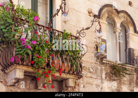 Fleurs sur un balcon fenêtre sur une maison à Taormina, Sicile, Italie Banque D'Images