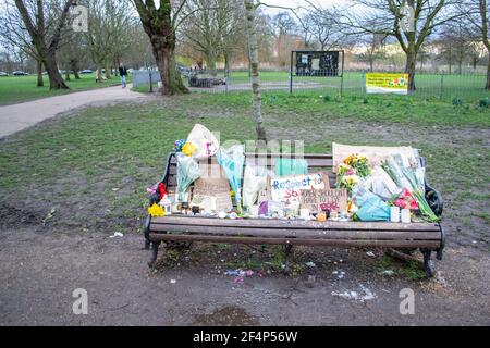 CLAPHAM, LONDRES, ANGLETERRE- 16 mars 2021 : fleurs et hommages sur un banc près de Clapham Common Bandstand, à la mémoire de Sarah Everard, assassinée b Banque D'Images