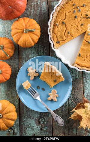 Dessert sain de Thanksgiving. Tarte traditionnelle à la citrouille avec croûte de wholegrain et graines de citrouille servies avec des biscuits d'homme de pain d'épice sur la décoration d'assiette bleue Banque D'Images