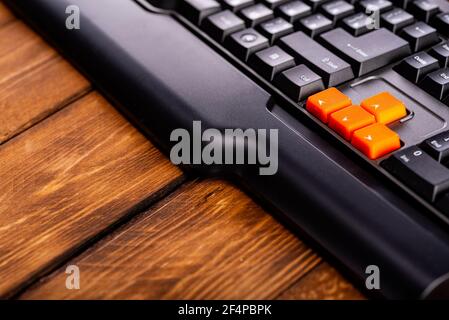 Touches fléchées orange sur un clavier noir, touches haut, bas, gauche, droite sur un clavier d'ordinateur de jeu. Banque D'Images