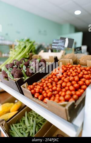 Tomates cerises fraîches et artichauts violets à un bio local marché Banque D'Images