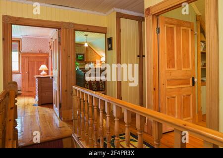 Couloir et portes ouvertes des chambres d'hôtes et de la salle de bains, balustrades d'escalier en bois d'érable à l'étage avec plancher de Hemlock de l'est dans la vieille maison Banque D'Images