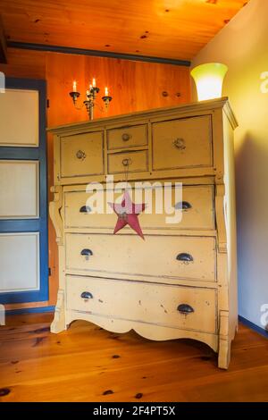 Commode en pin peint au babeurre antique à côté de bleu et porte blanche dans la chambre principale avec plancher en pin à l'intérieur de la vieille maison Banque D'Images