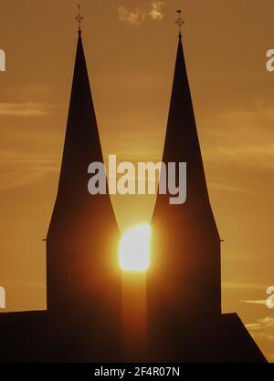 Neuruppin, Allemagne. 22 mars 2021. Le soleil se couche entre les tours de l'église monastère de Saint Trinitatis. Credit: Soeren Stache/dpa-Zentralbild/ZB/dpa/Alay Live News Banque D'Images