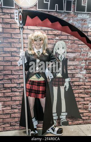 Une japonaise habillée comme Maka Albarn avec Soul Eater Scythe pose devant l'image de son personnage animé, Tokyo International Anime Fair, Japon Banque D'Images