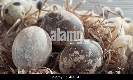 Composition de Pâques - plusieurs oeufs en marbre peints avec des teintures naturelles dans un nid en papier sur la table Banque D'Images