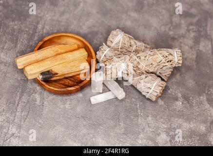 Bâtonnets de Palo Santo, sauge blanche séchée, cristaux sur fond gris. Banque D'Images