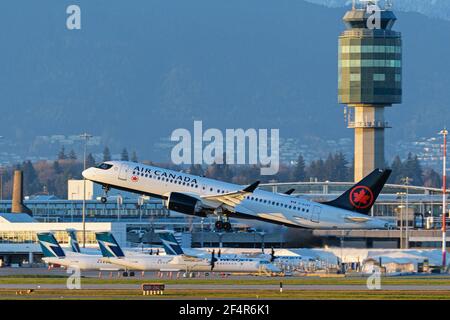 Richmond, Colombie-Britannique, Canada. 22 mars 2021. Un avion de ligne Airbus A220-300 d'Air Canada (C-GJXY) part de l'aéroport international de Vancouver. En arrière-plan, plusieurs avions de ligne régionaux WestJet encore Dash 8 sont stationnés par le terminal intérieur de l'aéroport. Crédit : Bayne Stanley/ZUMA Wire/Alay Live News Banque D'Images