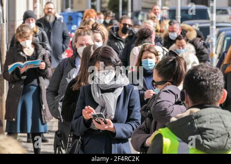 Berlin, Allemagne. 22 mars 2021. Les clients attendent en ligne pour entrer dans un magasin à Berlin, capitale de l'Allemagne, le 22 mars 2021. La chancelière allemande Angela Merkel et les gouvernements des États ont convenu qu'un « frein d'urgence », ou le renversement des relaxations, serait déclenché si le taux d'incidence des cas déclarés de COVID-19 pour 100,000 citoyens était supérieur à 100 dans un État ou une région pendant trois jours consécutifs. Credit: Stefan Zeitz/Xinhua/Alay Live News Banque D'Images