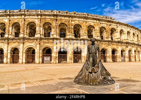 Nîmes, France - 15 mars 2021 : vue sur l'amphithéâtre romain de Nîmes avec la statue du taureau Nimeno Banque D'Images