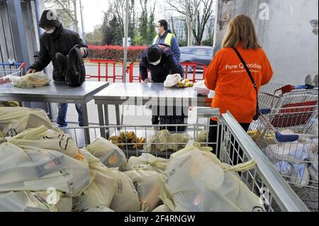 Milan (Italie), le volet organisme à but non lucratif Quotidiano (Daily Bread) distribue des denrées alimentaires essentielles aux personnes en difficulté économique en raison de la crise causée par l'épidémie du coronavirus. De plus en plus de groupes sociaux sont touchés, et chaque jour la file d'attente devient plus longue. Banque D'Images