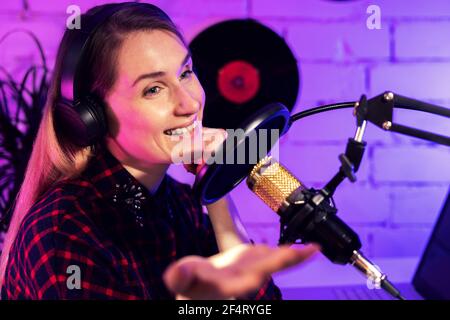 baladodiffusion en ligne - femme baladodiffusion ou hôte radio appréciant le travail en studio. parlant dans le microphone Banque D'Images