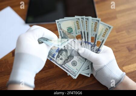 Homme en gants blancs comptant les dollars américains en gros plan Banque D'Images
