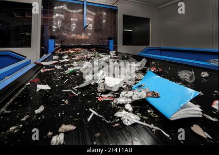 Déchets non triés sur un tapis transporteur pour le tri dans une usine de recyclage de matériaux au Royaume-Uni. Banque D'Images