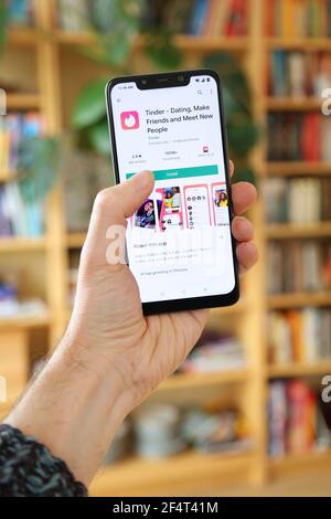 VARSOVIE, POLOGNE - 29 JANVIER 2021 : utilisateur installant l'application de rencontres en ligne Tinder sur un système d'exploitation Android, le smartphone de marque Xiaomi. Banque D'Images