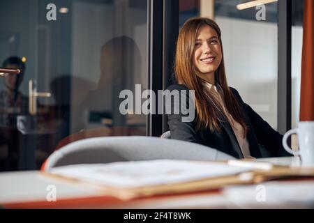 Femme d'affaires pleine d'esprit souriant à l'appareil photo Banque D'Images