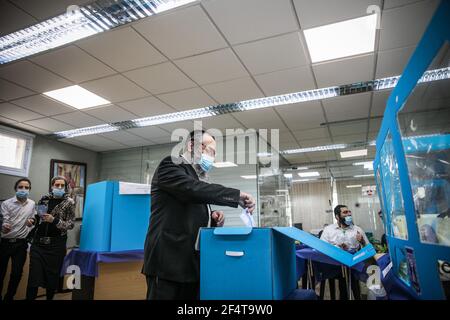 Jérusalem, Israël. 23 mars 2021. Un juif orthodoxe projette son vote à l'intérieur d'une boîte de vote dans un bureau de vote lors des élections parlementaires israéliennes. Credit: Noam Moskowitz/dpa/Alay Live News Banque D'Images