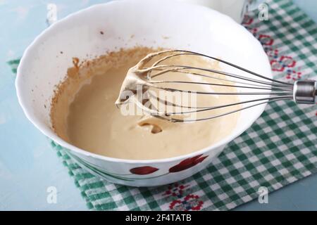 Du café fouetté avec du sucre dans une mousse moelleuse à l'aide d'un mélangeur, pour faire du café coréen Dalgona. Gros plan. Banque D'Images