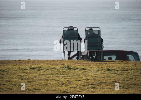 Homme et femme âgés dormant sur des transats au bord de la mer Banque D'Images