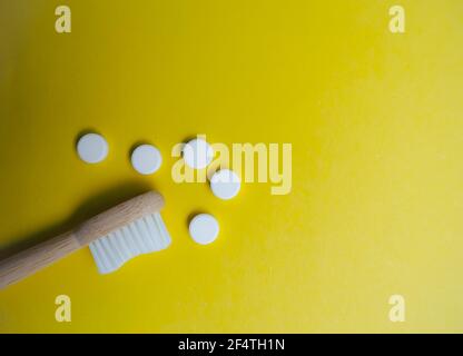 Brosse à dents en bambou et languettes dentaires sur fond jaune, sans plastique. Un style de vie sans gaspillage. Banque D'Images