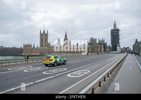 WESTMINSTER LONDRES, ROYAUME-UNI 23 MARS 2021. Une voiture de police conduit sur un pont calme de Westminster. Aujourd'hui marque l'anniversaire du premier confinement du coronavirus lorsque le gouvernement a demandé aux gens de dire à la maison, de sauver des vies et de protéger le NHS qui sera commémoré dans une journée nationale de réflexion avec un silence d'une minute pour se souvenir des 126,000 victimes qui sont mortes dans la pandémie de Covid. Credit amer ghazzal/Alamy Live News Banque D'Images