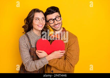 Portrait d'un couple affectueux et séduisant qui épouse la forme du cœur loin de l'amour isolé sur fond jaune vif Banque D'Images