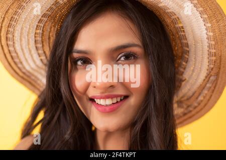 PORTRAIT D'UNE JEUNE FEMME REGARDANT L'APPAREIL PHOTO ET SOURIANT Banque D'Images