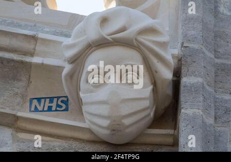 Sculpture d'un travailleur du NHS portant un masque sur le côté du Prieuré de Christchurch à Dorset pendant le troisième confinement national de l'Angleterre pour freiner la propagation du coronavirus. La sculpture est un hommage permanent aux efforts du service de santé pendant la pandémie et a été ajoutée au Prieuré - dont l'histoire remonte au milieu du XIe siècle - dans le cadre d'un projet visant à remplacer les gargouilles et les grottes endommagées. Date de la photo: Mardi 23 mars 2021. Banque D'Images