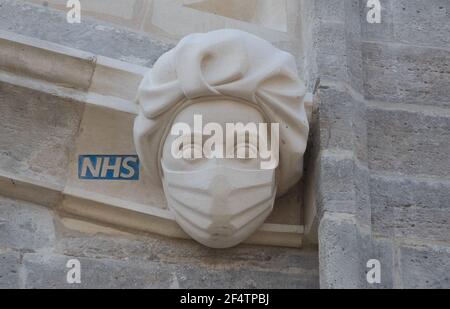 Sculpture d'un travailleur du NHS portant un masque sur le côté du Prieuré de Christchurch à Dorset pendant le troisième confinement national de l'Angleterre pour freiner la propagation du coronavirus. La sculpture est un hommage permanent aux efforts du service de santé pendant la pandémie et a été ajoutée au Prieuré - dont l'histoire remonte au milieu du XIe siècle - dans le cadre d'un projet visant à remplacer les gargouilles et les grottes endommagées. Date de la photo: Mardi 23 mars 2021. Banque D'Images