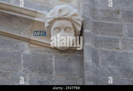 Sculpture d'un travailleur du NHS portant un masque sur le côté du Prieuré de Christchurch à Dorset pendant le troisième confinement national de l'Angleterre pour freiner la propagation du coronavirus. La sculpture est un hommage permanent aux efforts du service de santé pendant la pandémie et a été ajoutée au Prieuré - dont l'histoire remonte au milieu du XIe siècle - dans le cadre d'un projet visant à remplacer les gargouilles et les grottes endommagées. Date de la photo: Mardi 23 mars 2021. Banque D'Images