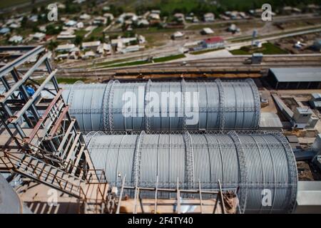 Usine de ciment standard. Hangars de l'entrepôt vue du haut. Effet d'inclinaison, partiellement flou. Banque D'Images