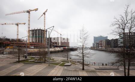 Hambourg, Allemagne. 23 mars 2021. Vue sur le chantier de construction de Strandkai à Grasbrookhafen à Hafencité avec la tour résidentielle de luxe 'The Crown' (l). La silhouette de l'Elbphilharmonie est visible en arrière-plan. Credit: Christian Charisius/dpa/Alay Live News Banque D'Images