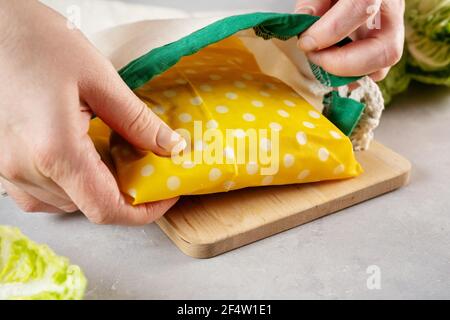 Les mains de femme plaçant le sandwich enveloppé dans un tissu de cire d'abeille dans le coton sac Banque D'Images