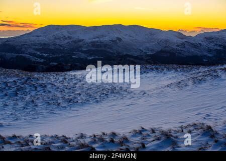 En regardant vers Coniston Old Man depuis Red Screes, Lake District, Royaume-Uni avec une lumière éclatante au coucher du soleil. Banque D'Images