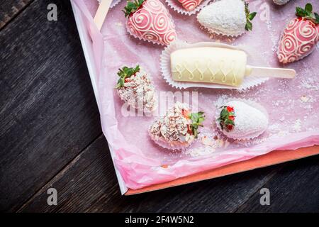 Fraises et bananes recouvertes de chocolat sur fond rustique. Mise au point sélective. Faible profondeur de champ. Banque D'Images