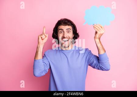Portrait d'un beau gars direct doigt vers le haut tenir la forme de nuage pull-over violet à col ouvert isolé sur fond rose Banque D'Images