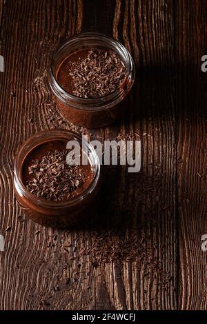 Mousse au chocolat noir maison dans des pots ruraux sur du bois rustique arrière-plan Banque D'Images