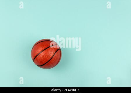 Petit ballon orange pour un match de basket-ball sur fond bleu. Banque D'Images