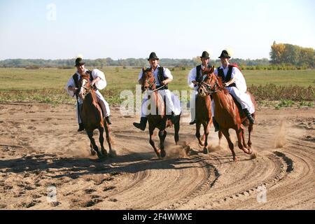 PUSZTA, HONGRIE, SEPTEMBRE 04. 2020: Bergers hongrois comme csikos en costume traditionnel folklorique montrant ses chevaux entraînés dans la chatzta hongroise lowl Banque D'Images