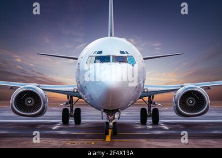 avion commercial à un aérodrome contre un coucher de soleil Banque D'Images