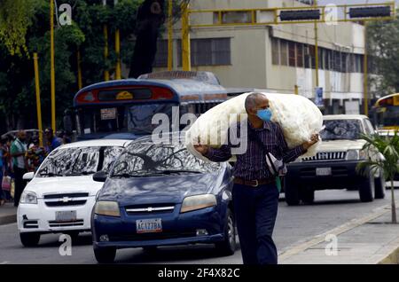 Valence, Carabobo, Venezuela. 23 mars 2021. 23 mars 2021.UN homme marche porter un sac de produits à vendre et porte un masque facial comme mesure de prévention des covirus. Photo: Juan Carlos HernÃndez crédit: Juan Carlos Hernandez/ZUMA Wire/Alay Live News Banque D'Images