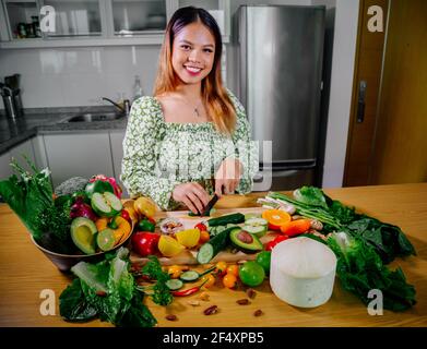 Une fille asiatique cuisant des aliments végétariens et végétaliens sains, des légumes et des fruits dans la cuisine, un mode de vie sain Banque D'Images