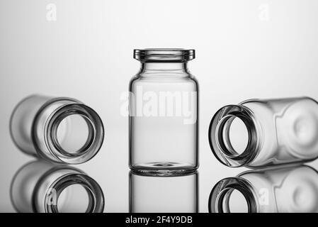 Bocaux en verre pour médicaments, capacité pour les médicaments liquides avec un col ouvert sans bouchon. Gros plan sur fond gris. Banque D'Images