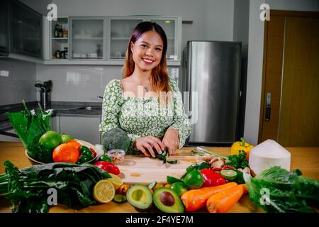 Une fille asiatique cuisant des aliments végétariens et végétaliens sains, des légumes et des fruits dans la cuisine, un mode de vie sain Banque D'Images