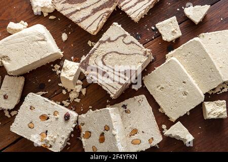 Le cacao et les amandes de la variété de la halva reposent sur un fond de table en bois. Morceaux de halvah ou de halwa à la vanille avec des noix et du chocolat. Dessert traditionnel confé Banque D'Images