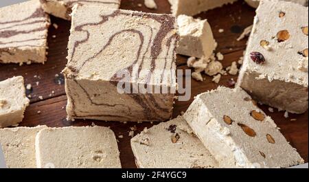 Cacao et amandes de la variété Halva sur fond de table en bois. Morceaux de halvah ou de halwa à la vanille avec noix, gros plan, confection de dessert traditionnelle faite avec de l'humour Banque D'Images